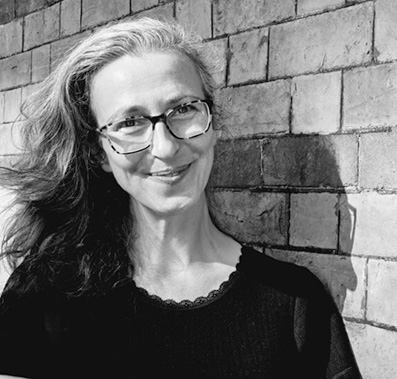 Black and white portrait of Anne against a brick wall